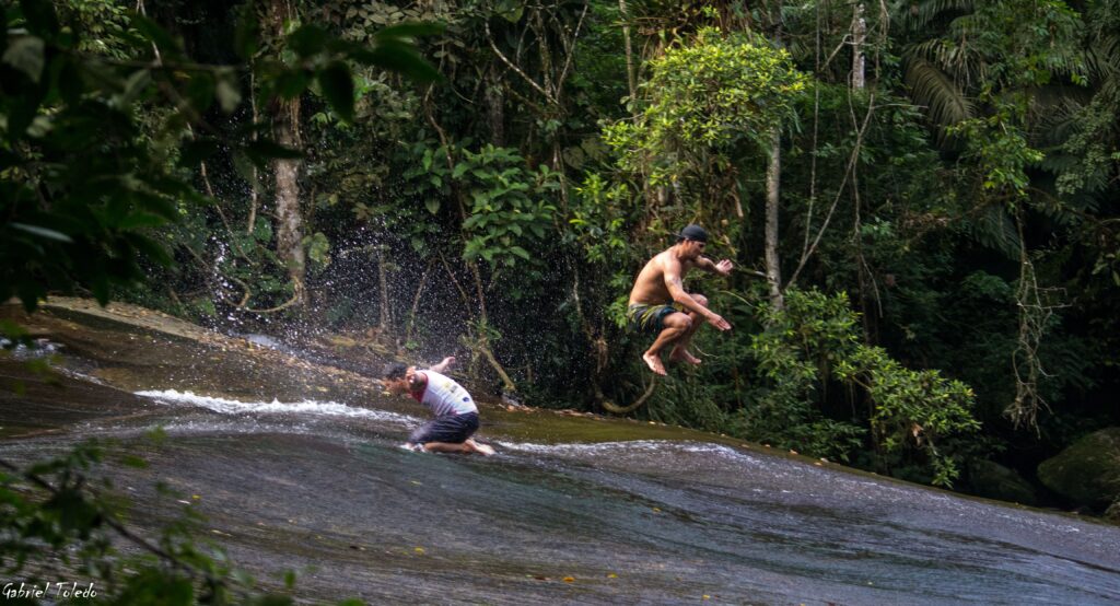 Rock surfer tricks at the Toboggan waterfall, paraty explorer-min